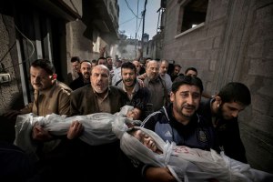 Погребение в Газа - палестински мъже носят телата на две малки деца, които са били убити по време на нападението на Газа през ноември 2012 година